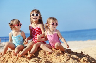 Happy kids playing at the beach in summer